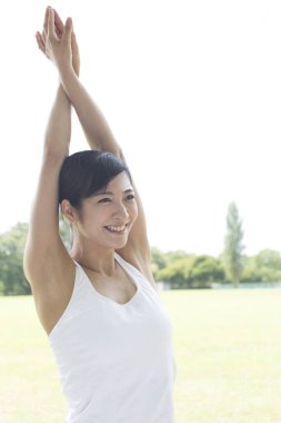 Güzel Japon kadın parkta yoga yapıyor.