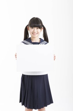 Okul üniformalı güzel bir öğrencinin portresi. Elinde beyaz bir tahta var.