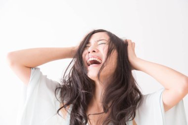 Elleri saçlarında neşeyle gülen bir kadın