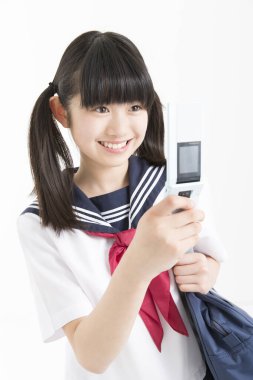 Okul üniformalı ve telefonlu güzel genç bir öğrencinin portresi.