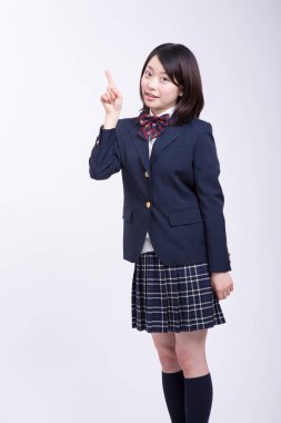 Üniformalı gülümseyen Japon öğrencinin stüdyo portresi.