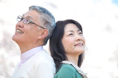 Güzel Asyalı olgun çifti ağaçlarla parka kapatın.