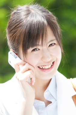 Akıllı telefon kullanan Asyalı genç bir kadının portresi. 