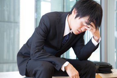 Başı ağrıyan takım elbiseli iş adamı 