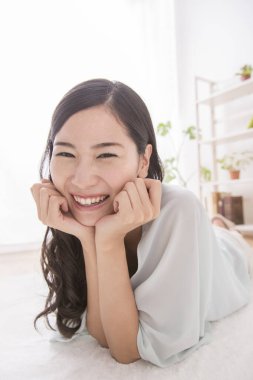 Evde gülümseyen Asyalı kadın.