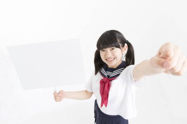 Okul üniformalı güzel bir öğrencinin portresi. Elinde beyaz bir tahta var.