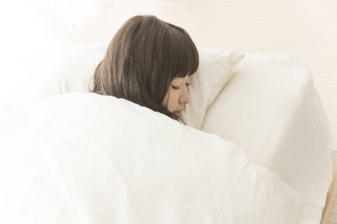 Yatakta uyuyan Asyalı kadın