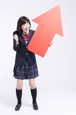 Kırmızı oklu gülümseyen Japon öğrencinin stüdyo portresi.