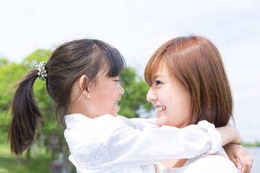 Anne ve kızı parkta sarılıyorlar.