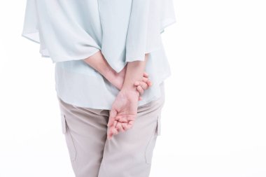 Ellerini beyaz arka planda tutan kadın.