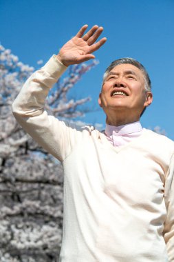 Elinde kiraz çiçeği olan son sınıf öğrencisi.