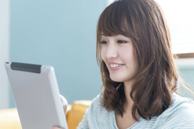 Asyalı kadın evde tablet kullanma