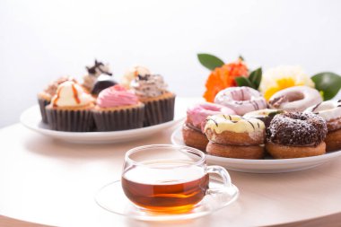 Tatlı ve lezzetli çörekler, tabakta kekler ve masada çay.