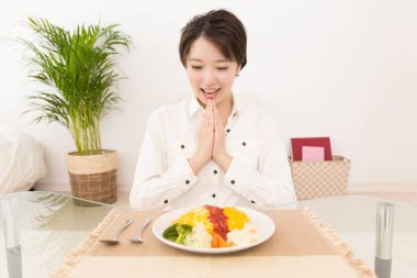 Güzel Japon kadın evde yemek yiyor.