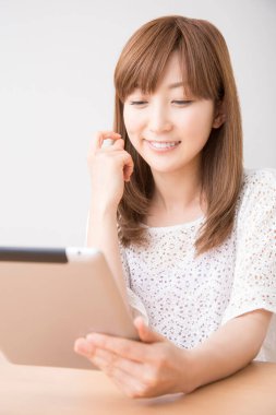 Tablet bilgisayarla çalışan Asyalı kadın
