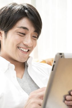 Genç Asina evde tablet kullanıyor. 