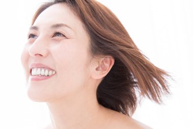 Güzel gülüşü olan Asyalı kadın beyaz arka planda izole edilmiş. 