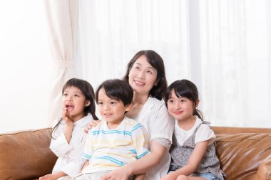 Üç çocuklu gülümseyen bir kadın.