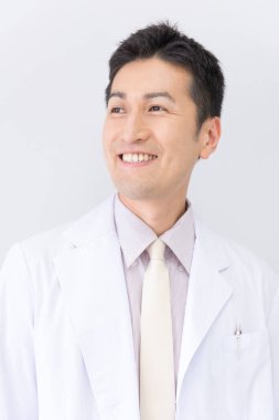 Beyaz laboratuvar önlüğü giymiş gülümseyen adam.