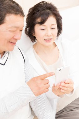 Akıllı telefona bakan Asyalı son sınıf çifti