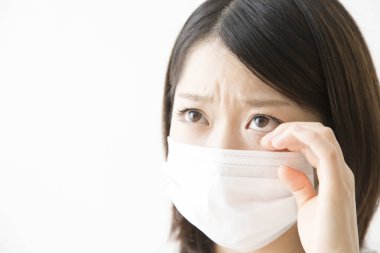 Soluk maskeli hasta bir Asyalı kadının portresi beyaza izole edilmiş.