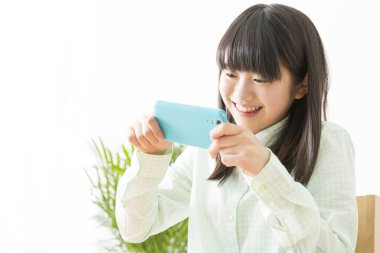 Akıllı telefon kullanan gülümseyen Japon kız.