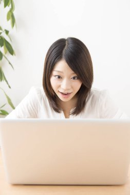 Evde dizüstü bilgisayarda çalışan Asyalı kadın.