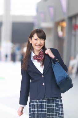 Üniformalı genç Asyalı kadın öğrencinin portresini yakından çek.