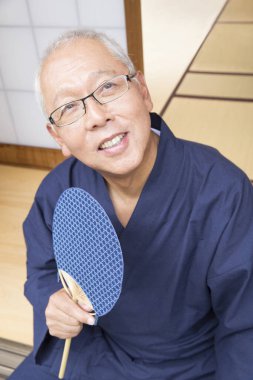 man holding a fan at home 