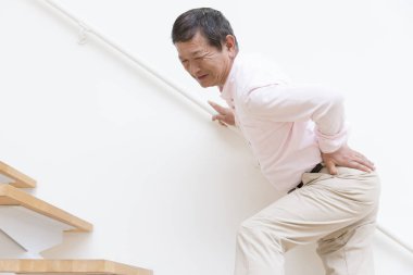 Merdivenlerde acı çeken Asyalı son sınıf öğrencisi.