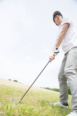 Golf oyuncusu sopayla topa vuruyor 