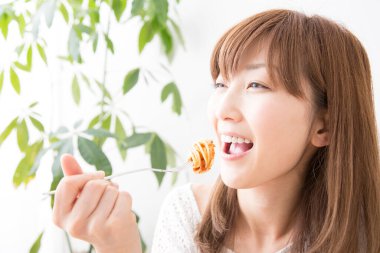 Evde spagettisi olan güzel bir Japon kadın.