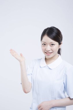 Beyaz üniformalı güzel Asyalı doktorun portresi.