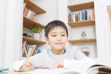 Asyalı çocuk ödevini yapıyor.