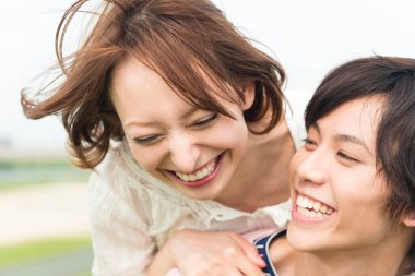 Bir çift mutlu genç Japon öğrenci doğada birlikte vakit geçiriyorlar.