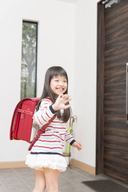 Sırt çantalı küçük Asyalı çocuk okula gidiyor. 