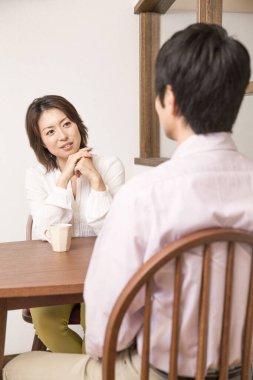 Genç Asyalı çift evde kahve içiyor. 