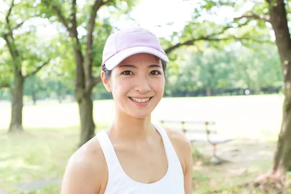 Sporty Japanese woman jogging in summer park