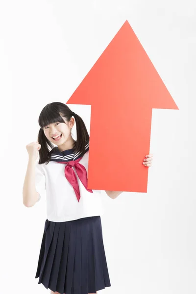 Malá Asijská Dívka Školní Uniformě Drží Červenou Šipku Znamení Izolované — Stock fotografie
