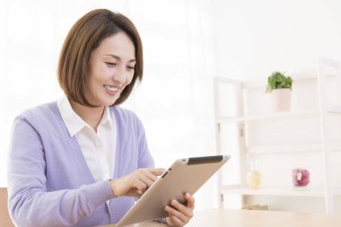 Tablet kullanan güzel Asyalı kadın.