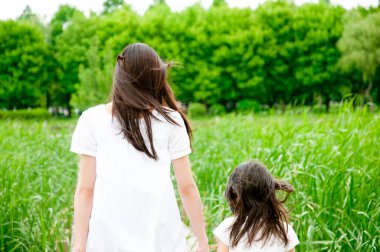 Genç anne ve küçük kızı parkta.