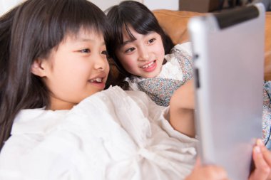 Tablet bilgisayar kullanan iki küçük kız.