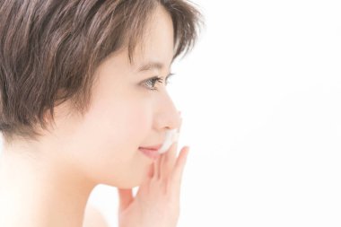 Beyaz arka planda beyaz tenli güzel bir Japon kadının yakın plan portresi.