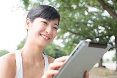 Kadın parkta Tablet PC'yi kullanma 