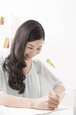 Evde okuyan genç bir kadın.