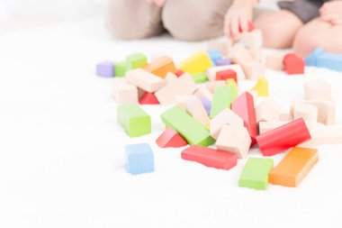 Anne ve kızı tahta küplerle oynuyorlar.