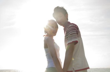 Mutlu Asyalı genç çift deniz kıyısında iyi eğlenceler.