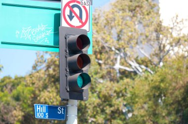 Trafik lambası açık hava levhalarının yanında yeşil sinyal gösteriyor.
