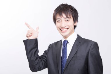 Siyah takım elbiseli Asyalı işadamı işaret ediyor