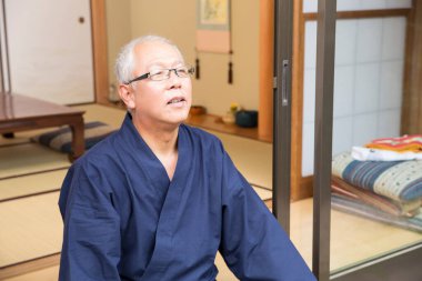 Olgun Asyalı adam yerde dinleniyor.